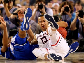 Shabazz Napier of the Connecticut Huskies (right) falls to the ground as Marcus Lee of the Kentucky Wildcats defends during the NCAA Final Four Championship game on Monday night at AT&T Stadium in Arlington, Texas. (Ronald Martinez/Getty Images/AFP)