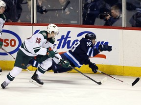 Winnipeg Jets forward Eric O'Dell (58) is tripped by Minnesota Wild defenseman Jonas Brodin (25) during the third period at MTS Centre. Minnesota won 1-0. (Bruce Fedyck-USA TODAY Sports)