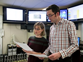 River forecaster Colleen Walford, left, and river forecasting section head Evan Friesenhan, right, discuss data at the River Forecast Centre in Edmonton, Alta., on Tuesday, April 8, 2014. Codie McLachlan/Edmonton Sun