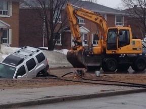 A car in sinkhole caused by a water main break in Trois-Rivieres, Tuesday, April 8, 2014. (Matthieu Max-Gessler/QMI Agency)