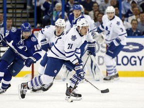 Maple Leafs’ David Clarkson avoids a check from the Lightning’s Teddy Purcell in Tampa last night. (AFP)