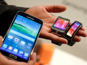 New Samsung Galaxy S5 smartphone (L), Gear 2 smartwatch (C) and Gear Fit fitness band are displayed at the Mobile World Congress in Barcelona Feb. 23, 2014. REUTERS/Albert Gea