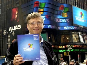 Microsoft Chairman Bill Gates holds up a copy of the new Windows XP operating system while posing for photos in New York's Times Square during the Windows XP launch in this Oct. 25, 2001 in New York. (AFP PHOTO/Henny Ray Abrams)