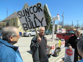 Plympton-Wyoming resident Ed Vanderaa holds a sign outside the town council chambers Wednesday befpre the start of a meeting between Suncor officials and town council over the company's Cedar Point wind project. The company and town were asked to meet by a judge hearing a Suncor challenge of several Plympton-Wyoming bylaws. PAUL MORDEN/THE OBSERVER/QMI AGENCY