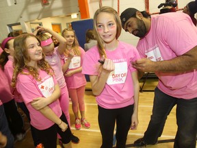 Lincoln Middle School students participated in the Red Cross Day of Pink celebration today. Former Winnipeg Blue Bomber Obby Khan signs sixth grade student Erin's shirt. (Chris Procaylo/Winnipeg Sun)