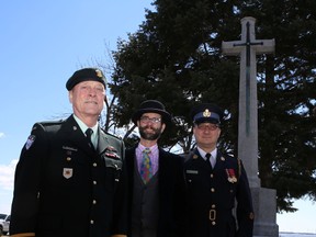 Art Jordan, Honorary Lieutenant-Colonel with the Princess of Wales' Own Regiment, left, and the Regimental Adjutant, Capt. Marc Gallant, right, join city curator Paul Robertson in front of the Cross of Sacrifice in McDonald Park. The cross is the subject of a refurbishment effort to restore it in time for Remembrance Day, when Canada will mark the 100th anniversary of the start of the First World War. 
ELLIOT FERGUSON/KINGSTON WHIG-STANDARD/QMI AGENCY