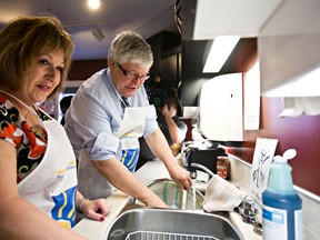 Minister of Culture Heather Klimchuk, left, washes dishes with Premier Dave Hancock, right, during a breakfast at the Ronald McDonald House for volunteers to acknowledge their contributions to Alberta families as part of National Volunteer Week in Edmonton, Alta., on Wednesday, April 9, 2014. Codie McLachlan/Edmonton Sun