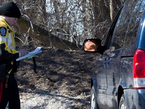 A motorist reacts to getting a speeding ticket as members of the Edmonton Police Service take part in speed enforcement along Scona Road at 94 Avenue, in Edmonton, Alta., on Thursday March 13, 2014. David Bloom/Edmonton Sun/QMI Agency