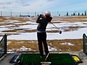 Matthew Zarowny hits a golf ball at the Mill Woods Golf Course driving range in March. (Codie McLachlan, Edmonton Sun)