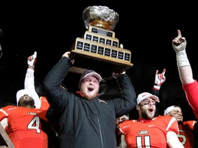 Laval Rouge et Or's Jean-Alexandre Bernier (centre) celebrates with teammates Pascal Lochard (left) and Guillaume Rioux after they defeated the Calgary Dinos to win the Vanier Cup in Quebec City, Nov. 23, 2013. (Reuters)