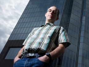 Bird expert Chris Guglielmo stands in front of a glass-sided building, many of which can be confusing to birds who can mistake mirrored images to be the real deal, in downtown London, Ontario on Thursday. CRAIG GLOVER/The London Free Press/QMI Agency