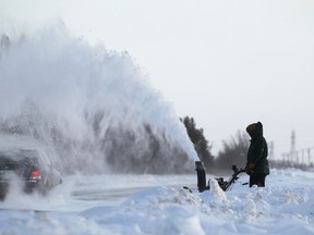 A car passes through a shower of snow from a snowblower on McCreary Road near Fort Whyte Alive earlier this winter. More snow could be on the way on Saturday. (Kevin King/Winnipeg Sun file photo)