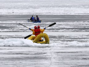 Kingston firefighters Shawn Wellbanks and Matthew Glen make their way across the ice to rescue three Queen's University students in a canoe on April 11, 2014.
ELLIOT FERGUSON/KINGSTON WHIG-STANDARD/QMI AGENCY
