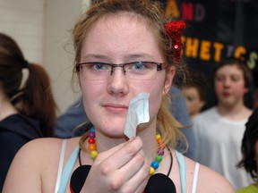 Amy Nickson, a Grade 11 student at Arthur Voaden Secondary School in St. Thomas, peels a nametag off her mouth after breaking a day-long Day of Silence on Friday, April 11, 2014. The Day of Silence is a national movement to draw attention to the silence faced by lesbian, gay, bisexual and transgender people. (Ben Forrest/Times-Journal)