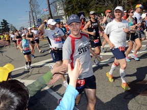 Runners high five spectators along the route of Boston Marathon, a part of the race that Sarnia runners Dave Caraher and Wes Harding say is extremely memorable. 11 Lambton runners will be participating in the 118th running of the Boston Marathon on Monday, April 21.  (Observer file photo)