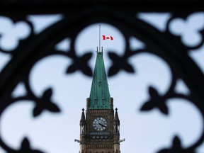 The flag on the Peace Tower is lowered, following the news of former Finance Minister Jim Flaherty's death, on Parliament Hill in Ottawa April 10, 2014. (REUTERS/Blair Gable)