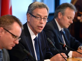 Canada's Finance Minister Joe Oliver (C) makes remarks to the press as G7 and G20 Deputy Minister Jean Boivin (L) and Bank of Canada Governor Stephen Poloz listen during the IMF/World Bank 2014 Spring Meetings in Washington April 11, 2014. (REUTERS/Mike Theiler)