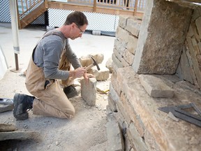 Patrick Callon works to build a dry stone wall at the show. The 38th annual show features more than 320 exhibits with thousands of products and services for homes and gardens. (CRAIG GLOVER, The London Free Press)