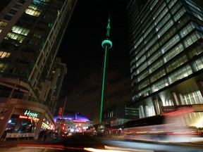 The CN Tower in Toronto is illuminated green on Friday April 11, 2014, to honour Jim Flaherty, who passed away Thursday afternoon at his condominium in Ottawa. (Stan Behal/Toronto Sun/QMI Agency)