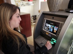 Reporter Allison Salz uses a bank machine at a restaurant in Edmonton, Alberta on Wednesday, Apr 9, 2014. Perry Mah/ Edmonton Sun/ QMI Agency