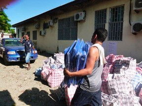 A worker carries aid as he prepares to load a truck before heading to earthquake and tsunami affected areas in Honiara, Solomon Islands February 7, 2013.  REUTERS/World Vision/Handout