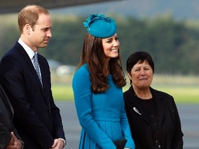 Catherine (C), the Duchess of Cambridge, stands with her husband, Britain's Prince William (L) and a local official after arriving in Dunedin April 13, 2014. (REUTERS/Phil Noble)