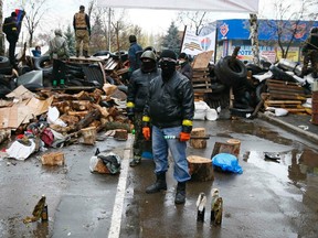 Pro-Russian armed men stand guard while pro-Russian protesters gather near the police headquarters in Slaviansk April 13, 2014. REUTERS/Gleb Garanich