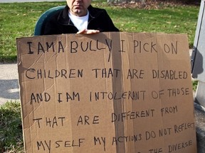 Edmond Aviv, 62, sits with a sign he made at a street corner in the Cleveland suburb of South Euclid, Ohio April 13, 2014.  (AARON JOSEFCZYK/REUTERS)