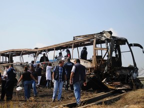 Forensic staff and red cross members inspect a bus after a crash on a highway near Juan Rodriguez Clara town, in Veracruz state, April 13, 2014. (REUTERS/Angel Hernandez)