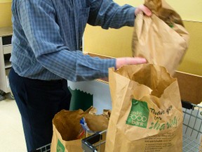 Josh Chadwick, an employee of the London Food Bank unloads groceries from a grocery store bin in London, Ont. on Sunday April 13, 2014. Glen Pearson of the Food Bank said the numbers were good over the weekend. (MIKE HENSEN, The London Free Press)