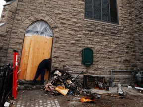 A man boards up a door at St. James Church at 60 Promenade du Portage in Gatineau, QC, where firefighters managed stop a fire that started in the lobby Sunday April 13, 2014. The church is under renovations to become a restaurant and its the third time a church burned on the site. 
Darren Brown/Ottawa Sun/QMI Agency