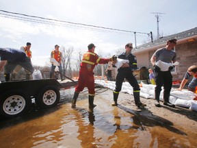 Members of Belleville Fire Department and city workers give a hand to River Road homeowner Ann Colebourne in Corbyville, Ont. Saturday, April 12, 2014.  - Jerome Lessard/The Intelligencer/ QMI Agency