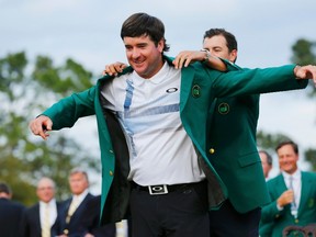 Masters winner Bubba Watson, has 2013 winner Adam Scott (R), present him his green jacket after winning the Masters golf tournament at the Augusta National Golf Club in Augusta, Georgia April 13, 2014. (REUTERS)