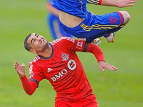 TFC striker Gilberto can only watch as Colorado’s Drew Moor goes up for a ball on Saturday. (MICHAEL PEAKE/Toronto Sun)