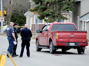 Det. Const. Paul Smith, left, of the Brockville Police Service's forensic unit, and Const. Mike Boszormeny, right, confer with a colleague from the Ontario Provincial Police Sunday evening as they investigate a fatal colliision between the pickup truck at right and a pedestrian Sunday afternoon.
RONALD ZAJAC/QMI AGENCY