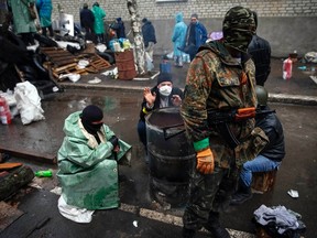 Pro-Russian men gather around a fire at a barricade near the police headquarters in Slaviansk April 13, 2014. REUTERS/Gleb Garanich