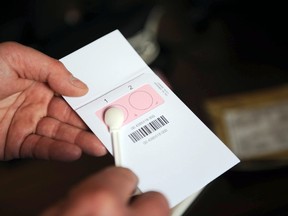 The departmental director of public safety, Olivier Le Gouestre, shows the DNA kit during a press conference at La Rochelle tribunal, western France, on April 14, 2014. More than 500 male students and staff at a French high school undergo DNA tests in a bid to discover the rapist of a 16-year-old girl who was assaulted in a dark toilet.  AFP PHOTO / XAVIER LEOTY