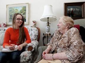 Megan Klak, 17, chats with Irene McBean in Edmonton recently. Klak volunteers at a seniors' home, helping residents write their stories. (David Bloom/Edmonton Sun)