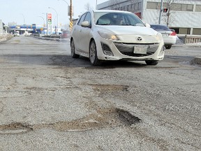 A motorist passes a series of potholes on Taylor Avenue earlier this year. The state of streets and roads were cited by Winnipeggers as the city's most pressing concern in a recent poll. (BRIAN DONOGH/WINNIPEG SUN FILE PHOTO)