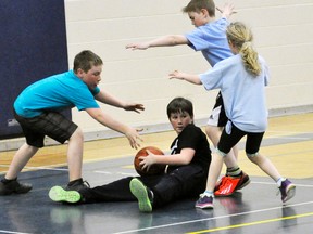 Calvin Niles of the Heat is surrounded by Warriors’ defenders Caleb Tweddle (left), Kurt Visser and Emma French during action from the Mitchell Minor Basketball junior championship game April 9 at the Mitchell District High School (MDHS). The Heat won a nailbiter, 5-4, thanks to a free throw “shoot off.” ANDY BADER/MITCHELL ADVOCATE