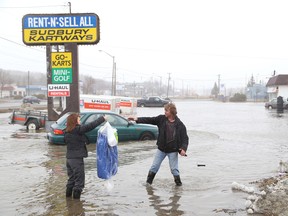 JOHN LAPPA/THE SUDBURY STAR/QMI AGENCY 
Phil Dalle Vedove, right, of Rent-N'-Sell All on Notre Dame Avenue, collects an item from customer Lori Glibbery on Monday, April 14, 2014 in Sudbury, ON. Flooding occurred at a number of businesses on Notre Dame Avenue. See video at www.thesudburystar.com