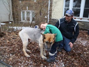 JOHN LAPPA/THE SUDBURY STAR
William Haskett, 4, hugs the family dog, Partner, as William's dad, Neil, looks on outside the family home on Monday.