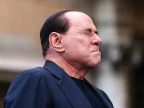 Former Italian Prime Minister Silvio Berlusconi closes his eyes in a gesture to supporters during a rally to protest his tax fraud conviction, outside his palace in central Rome in this August 4, 2013 file photo. REUTERS/Alessandro Bianchi/Files
