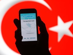 A person holds holds a Samsung Galaxy S4 displaying a Twitter error message in front of Turkish national flag in this illustration taken in Zenica, March 21, 2014.  REUTERS/Dado Ruvic