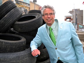 Jay Stanford, director, environment, fleet and solid waste for the City of London, leans against a pile of 110 tires in front of Budweiser Gardens April 15, 2014 in London, Ont. Stanford launched the 19th London Clean and Green, 12 days of environment cleaning initiatives that includes free tire recycling. CHRIS MONTANINI\LONDONER\QMI AGENCY