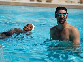 U.S. swimmer Michael Phelps stands in a pool during a visit to the Rocinha slum complex ahead of the Laureus World Sports Awards in Rio de Janeiro March 11, 2013. (REUTERS/Pilar Olivares)