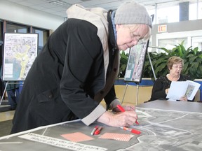 Victims of Chemical Valley member Martha Fracalanza marks a map of Centennial Park while fellow member Margaret Buist reads a report at Sarnia city hall Tuesday, April 15, 2014. Members of the group were on hand for a public meeting on the planned multimillion-dollar remediation of the waterfront park. (BARBARA SIMPSON, The Observer)