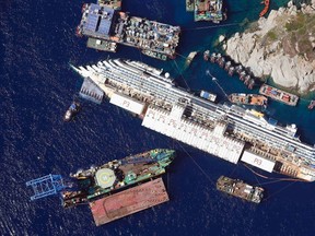 An aerial view shows the Costa Concordia as it lies on its side next to Giglio Island taken from an Italian navy helicopter August 26, 2013. (REUTERS/Alessandro Bianchi)