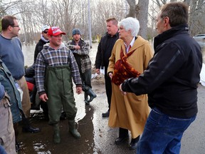 Ontario education minister Liz Sandals talks with Foxboro, Ont. resident Derrick Swoffer, centre, outside his flooded home Wednesday, April 16, 2014. Flanking Sandals are Fire Chief Mark MacDonald and Mayor Neil Ellis, far right. She praised the community effort to help flood victims. Luke Hendry/The Intelligencer/QMI Agency