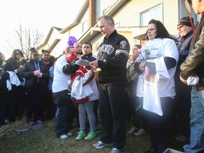 Chris Jobe leads a prayer at a vigil Wednesday night for Andrea White, near where she was slain in her housing complex near Morningside and Old Finch Aves. on April 12, 2014. White's mother, Wendy White, wears a white T-shirt with her daughter's picture on it. (